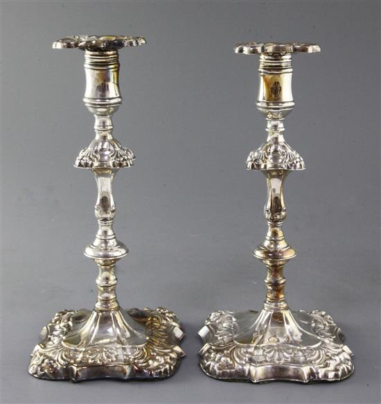 A pair of George III embossed silver candlesticks by James Stamp and John Baker, 10in.